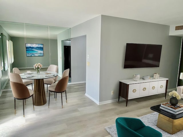 living area with light wood-style flooring, baseboards, and visible vents