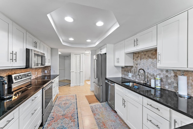 kitchen featuring light tile patterned flooring, stainless steel appliances, white cabinetry, and sink