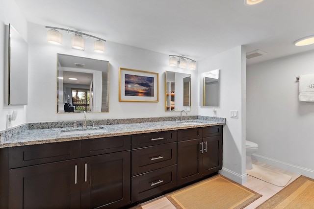 bathroom with vanity, toilet, and wood-type flooring