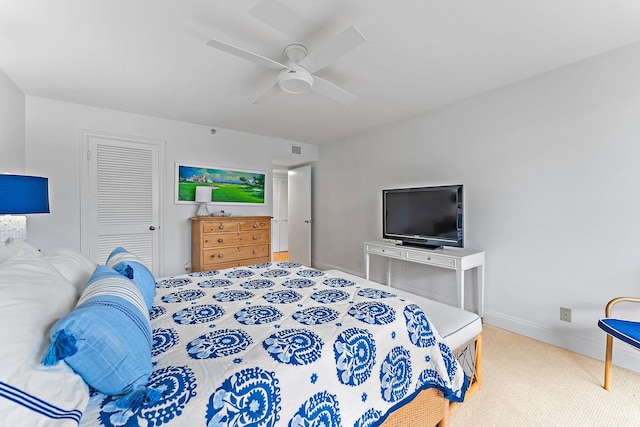 bedroom with ceiling fan, a closet, and light carpet