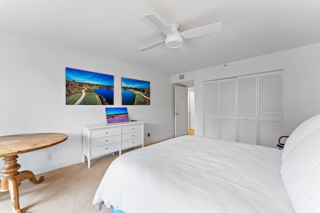 bedroom with a closet, ceiling fan, and light carpet