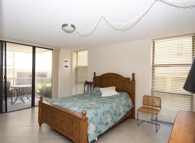 bedroom featuring access to outside and a textured ceiling