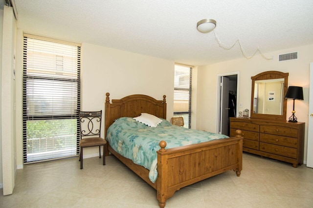 bedroom featuring multiple windows and a textured ceiling