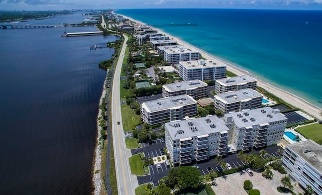 birds eye view of property featuring a water view and a beach view