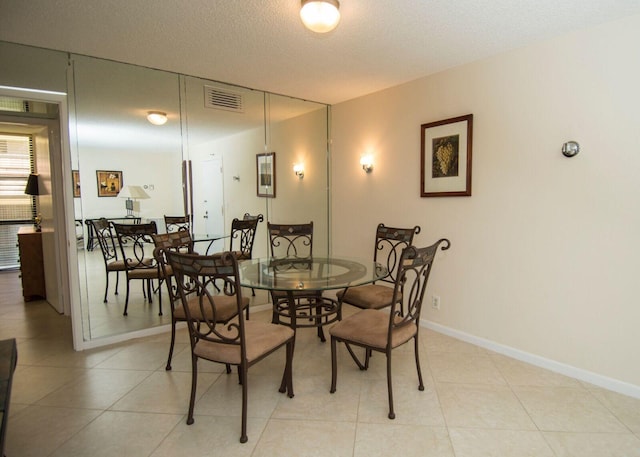 tiled dining space featuring a textured ceiling