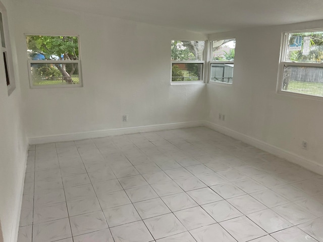 empty room with plenty of natural light and light tile patterned flooring