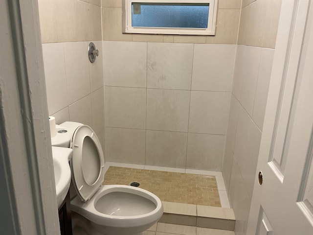 bathroom with tile patterned floors, a shower, toilet, and tile walls