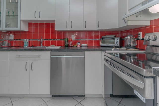 kitchen with white cabinets, backsplash, stainless steel appliances, and extractor fan