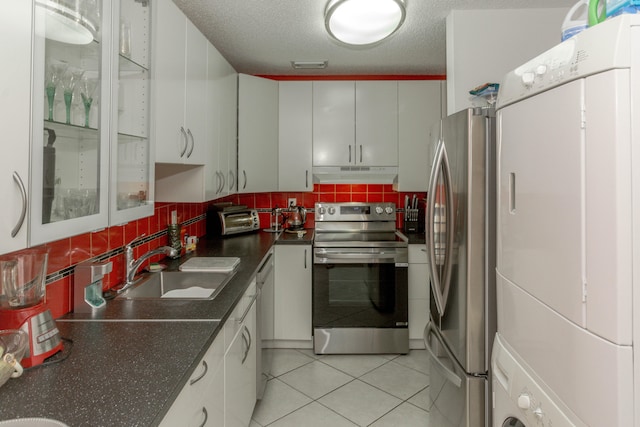 kitchen with white cabinets, backsplash, stainless steel appliances, and a textured ceiling