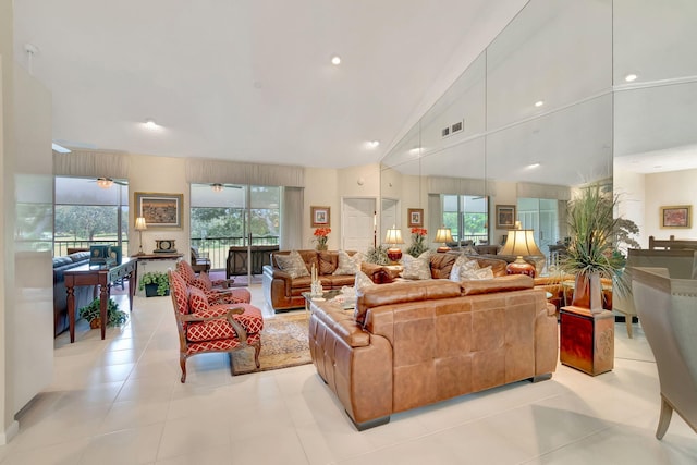 living room with lofted ceiling, ceiling fan, and light tile patterned flooring