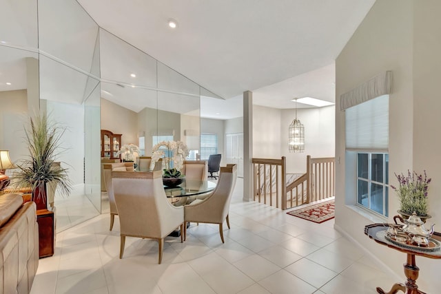 tiled dining room with vaulted ceiling and a notable chandelier