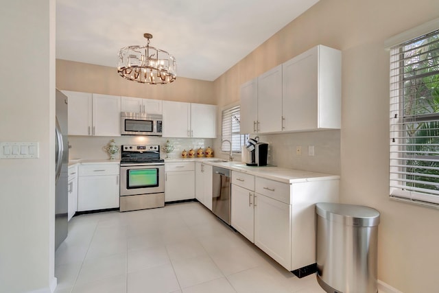 kitchen with a healthy amount of sunlight, stainless steel appliances, and white cabinets