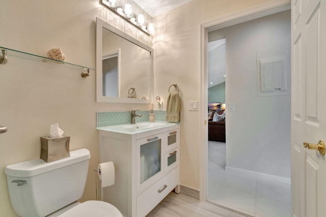 bathroom featuring vanity, toilet, decorative backsplash, and tile patterned floors