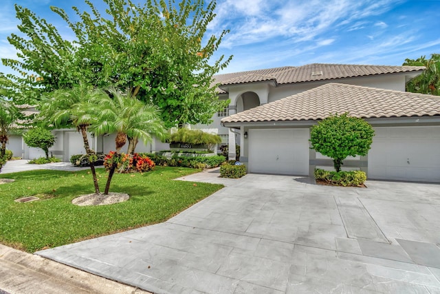 mediterranean / spanish home with a garage and a front lawn