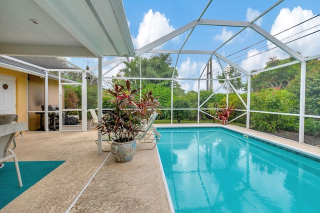 view of swimming pool featuring a patio and a lanai