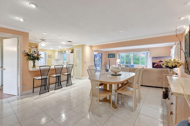 tiled dining room with crown molding, a textured ceiling, and ceiling fan