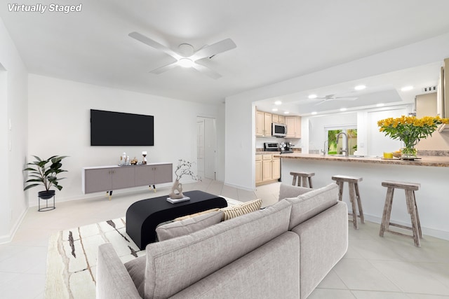 living room with sink, ceiling fan, and light tile patterned flooring