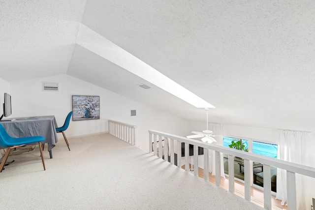 bonus room with carpet, ceiling fan, lofted ceiling with skylight, and a textured ceiling