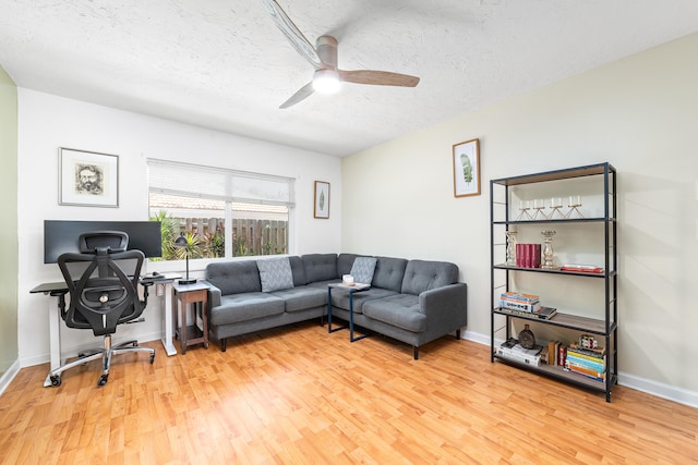 living room with hardwood / wood-style floors, a textured ceiling, and ceiling fan