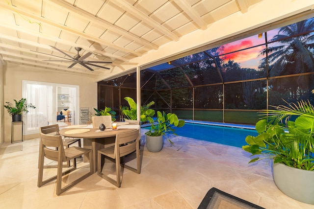 pool at dusk featuring ceiling fan