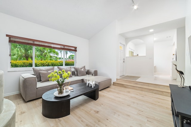 living room featuring light wood-type flooring and vaulted ceiling