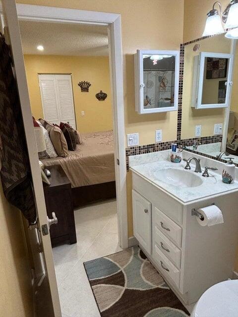 bathroom with a textured ceiling, vanity, and tile patterned floors