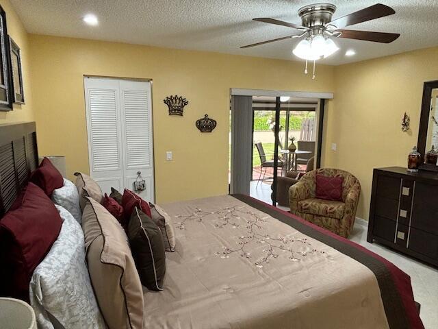 carpeted bedroom featuring a closet, ceiling fan, access to exterior, and a textured ceiling