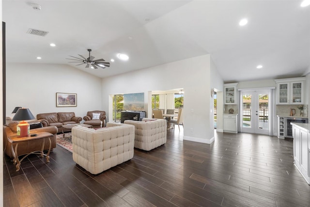 living room featuring dark wood-type flooring, ceiling fan, and vaulted ceiling