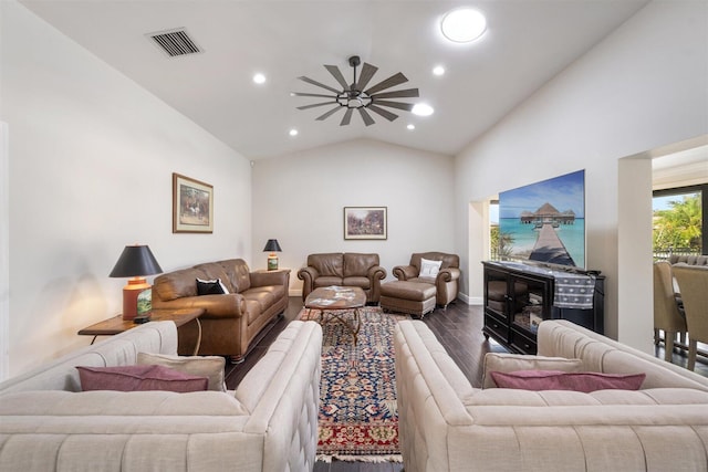 living room with hardwood / wood-style flooring, ceiling fan, and vaulted ceiling