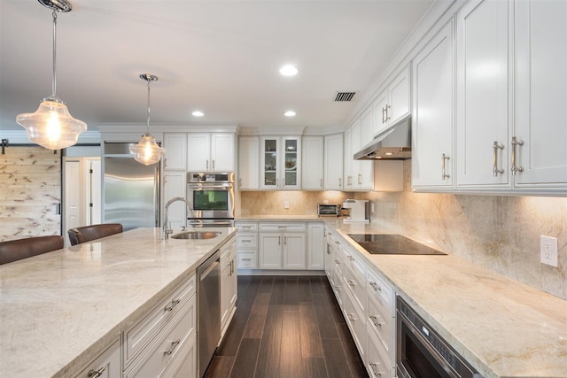 kitchen featuring light stone counters, white cabinets, sink, pendant lighting, and appliances with stainless steel finishes