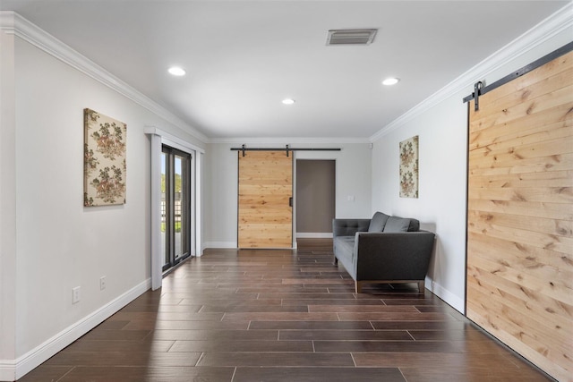 sitting room featuring a barn door, dark hardwood / wood-style floors, and crown molding