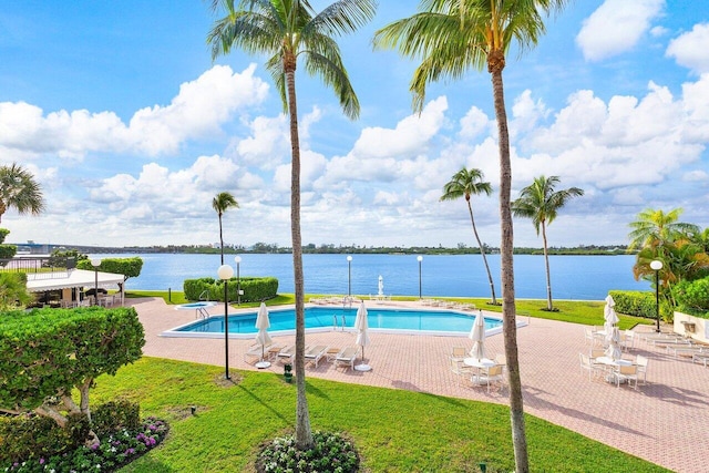 view of pool with a patio area and a water view