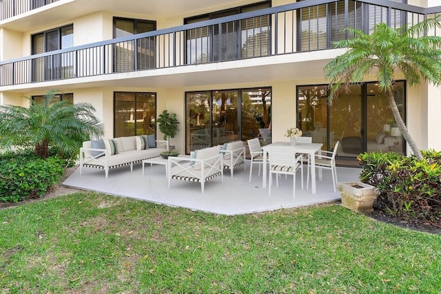 back of property with stucco siding, a yard, an outdoor living space, and a patio