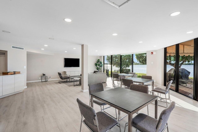 dining room with expansive windows and light hardwood / wood-style flooring