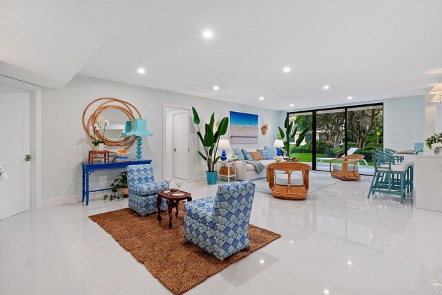 kitchen featuring white cabinets, stainless steel refrigerator, a wealth of natural light, and a kitchen island with sink