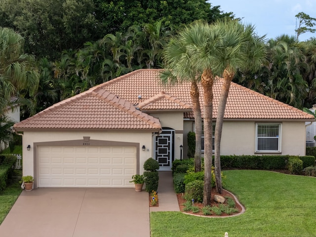 mediterranean / spanish-style house featuring a front lawn and a garage