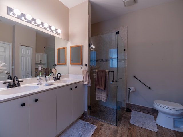 bathroom with a shower with shower door, wood-type flooring, toilet, and vanity