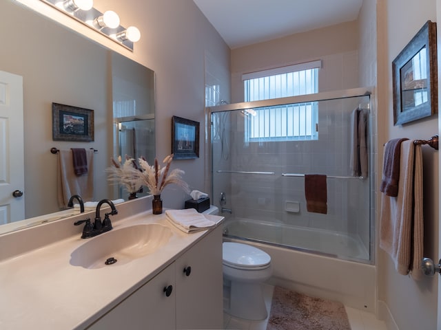 full bathroom with tile patterned flooring, vanity, toilet, and combined bath / shower with glass door