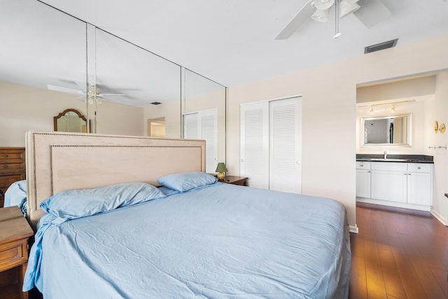 bedroom with dark wood-style floors, a sink, ceiling fan, and a closet