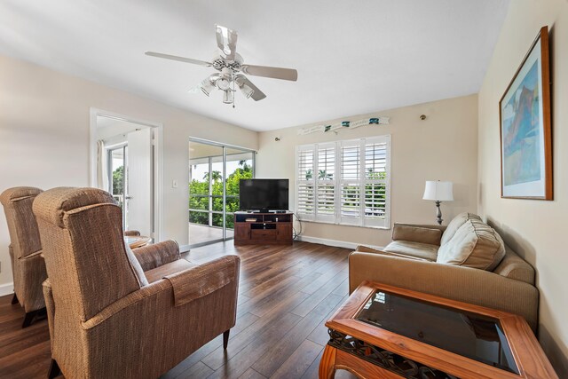 living room with ceiling fan and dark hardwood / wood-style flooring