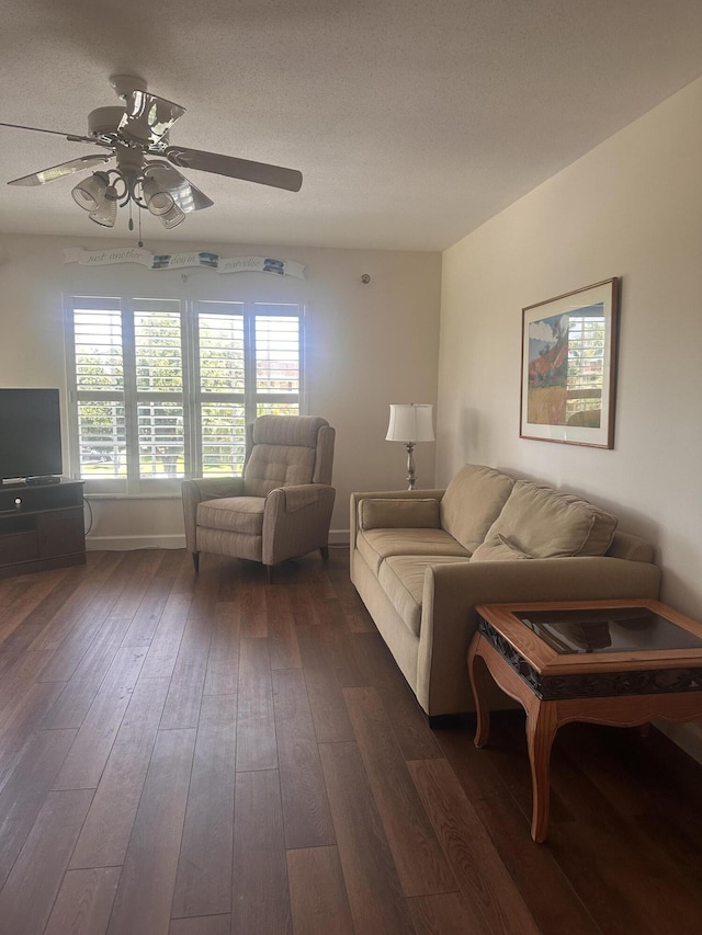 living room with ceiling fan, dark wood-style flooring, plenty of natural light, and a textured ceiling