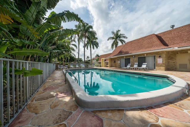 community pool featuring fence and a patio area