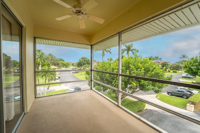 unfurnished sunroom with ceiling fan