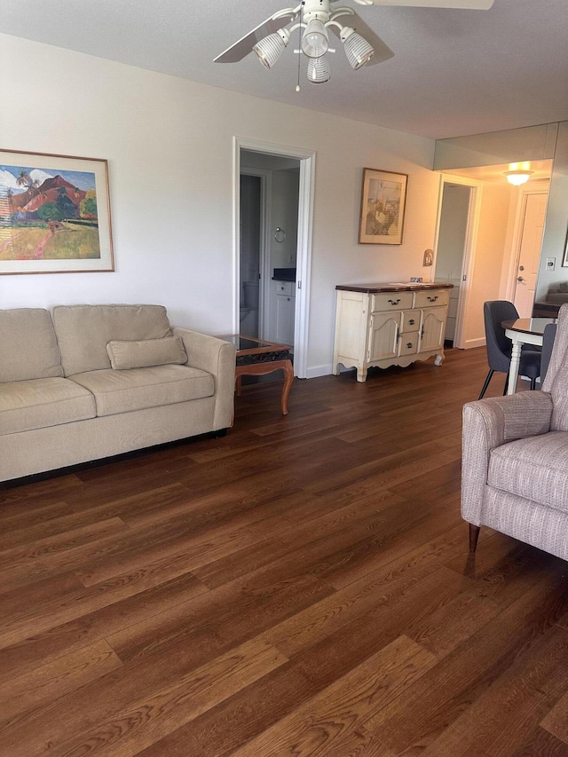 living area featuring dark wood-style floors and ceiling fan
