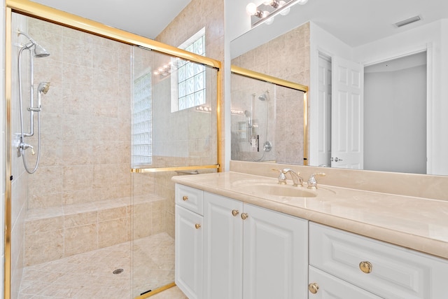 bathroom with vanity and a shower with door