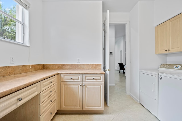 clothes washing area featuring light tile patterned flooring, cabinets, and independent washer and dryer