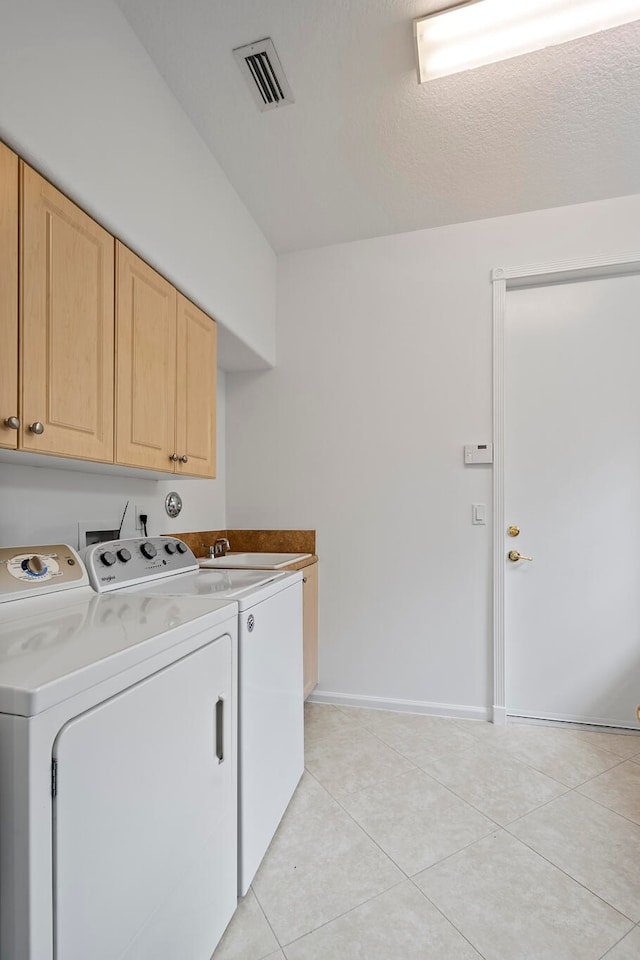 laundry room featuring separate washer and dryer, sink, light tile patterned flooring, and cabinets