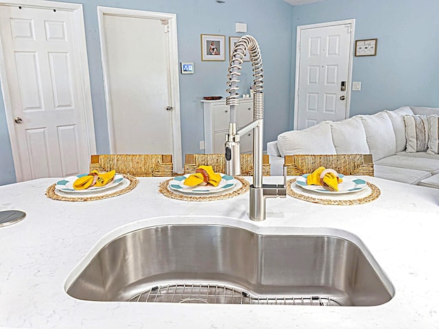 222 SW Starfish Ave, Port Saint Lucie, FL 34984 - kitchen featuring a sink, open floor plan, and light stone countertops