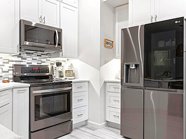 222 SW Starfish Ave, Port Saint Lucie, FL 34984 - kitchen with appliances with stainless steel finishes, light countertops, backsplash, and white cabinetry