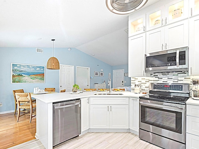 kitchen featuring hanging light fixtures, appliances with stainless steel finishes, light hardwood / wood-style floors, white cabinetry, and sink